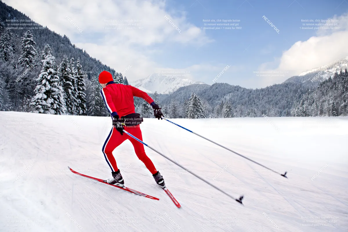 A skier is captured mid-action against a dramatic wintry backdrop of snow, pine trees, and mountains. The image emphasizes movement, fresh powder, and the expansive natural beauty awaiting guests at Anthony Lakes.