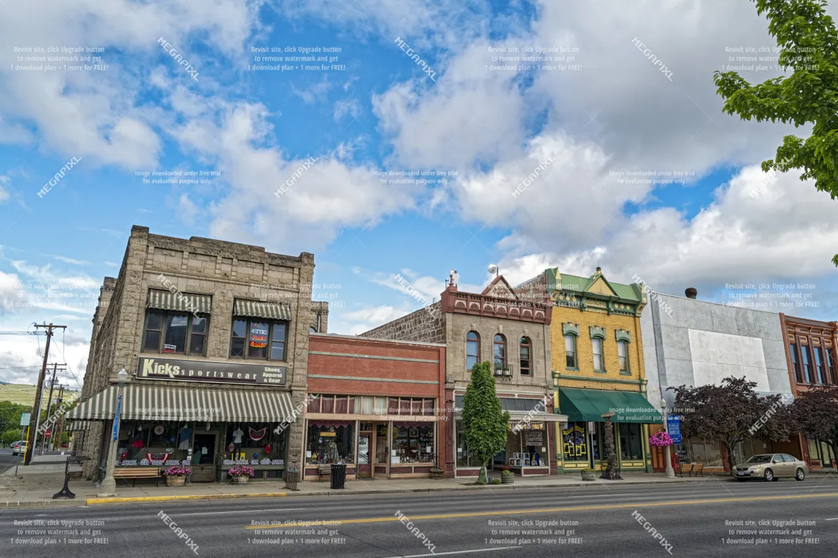 A charming streetscape featuring historic buildings and storefronts lined with street trees. The scene invites leisurely strolls, shopping, and exploring local attractions along a welcoming Main Street.